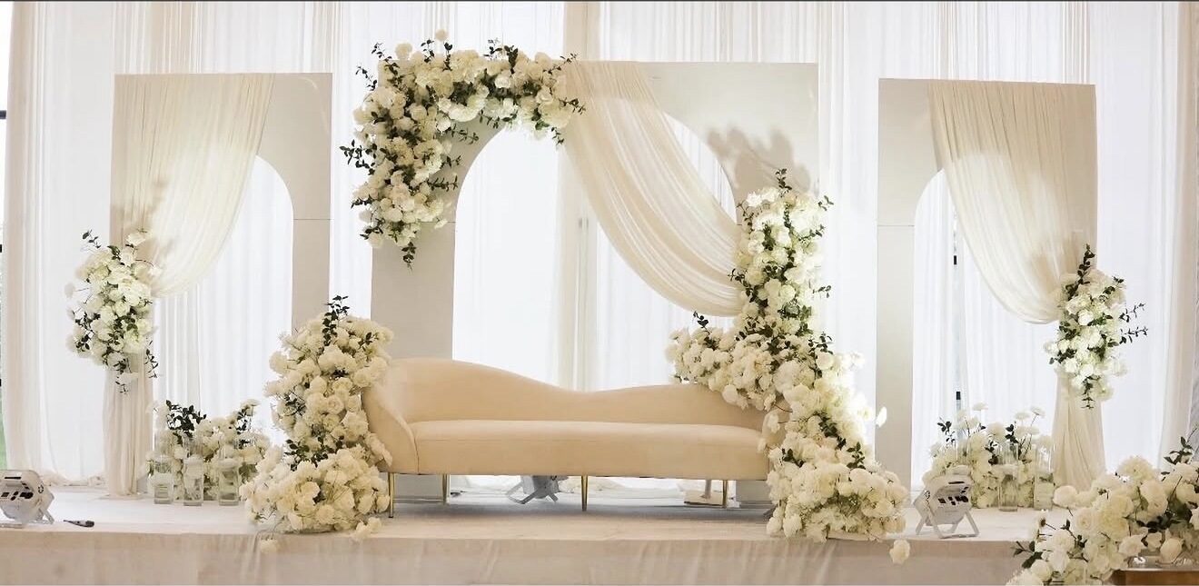 Ivory arches glowing with warm ambient lighting behind a cream sofa