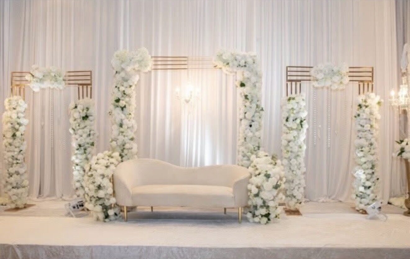 All-white floral pillars framing an elegant cream sofa